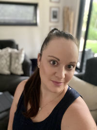 Portrait of a smiling young woman sitting at home