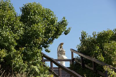 Low angle view of animal sculpture against clear sky