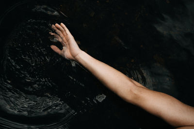 High angle view of woman touching water