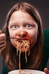 Close-up portrait of woman eating noodles