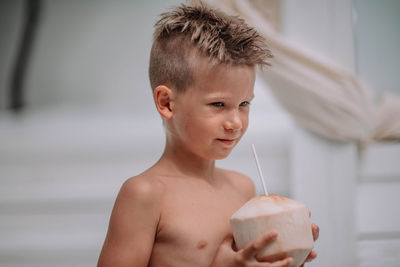 Portrait of shirtless boy drinking glass