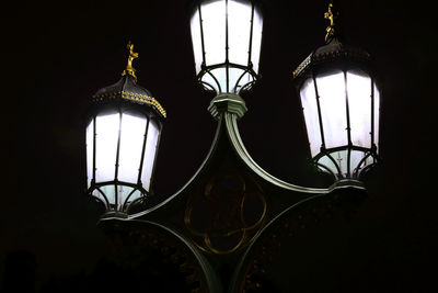 Low angle view of illuminated lamp hanging against window