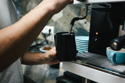 Midsection of man holding coffee cup