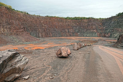 View of rock formation on road against sky