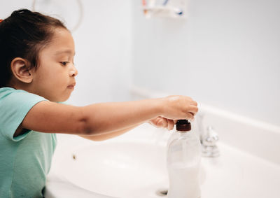 Cute girl washing hand at sink