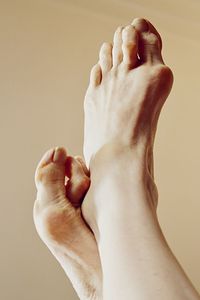 Low section of human feet against colored background