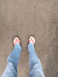 Low section of man standing on sand