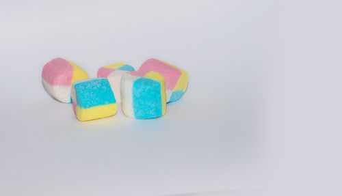 Close-up of multi colored candies against white background