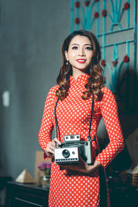 Smiling young woman with vintage camera