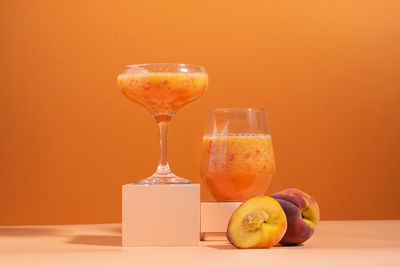 Close-up of drink on table against orange background