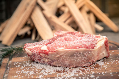 Italian steak ready to be cooked on a barbecue. appetizing piece of meat next to a pyre of firewood 