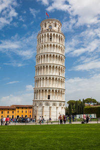 Tourists at the leaning tower of pisa in a beautiful early spring day