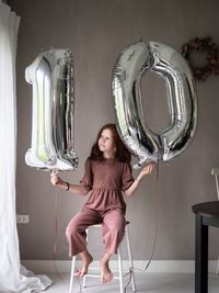 Full length portrait of happy woman standing at home