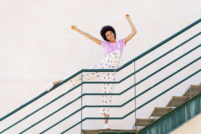 Low angle view of young woman standing on staircase