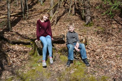 Full length portrait of happy mother and daughter against trees