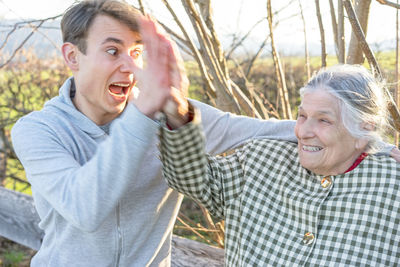 Happy grandmother giving high five with grandson on field