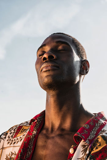 LOW ANGLE VIEW OF MAN AGAINST SKY