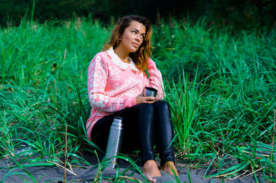 Thoughtful woman sitting on field