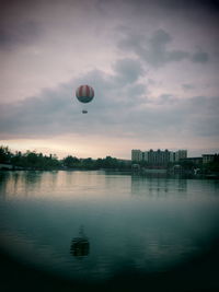 Hot air balloon flying over city against sky