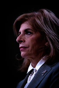 Portrait of woman against black background