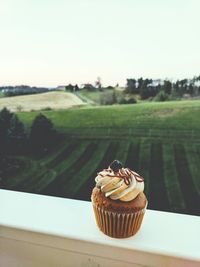 Close-up of cake on table against sky