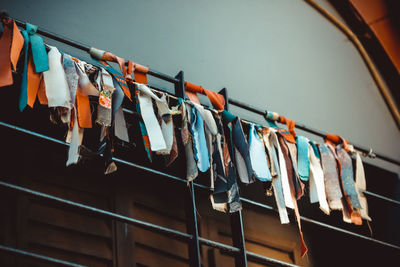 Low angle view of clothes drying on clothesline against wall