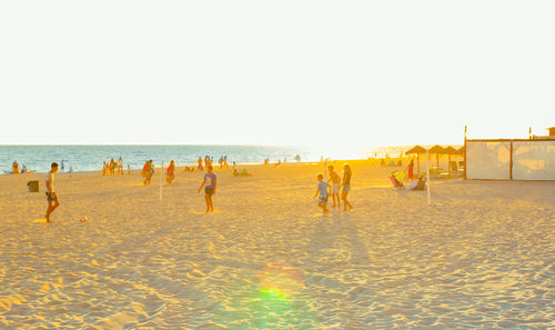 People on beach against clear sky