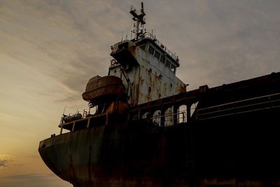 Low angle view of abandoned ship on sea against sky