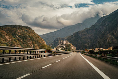 Road by mountain against sky