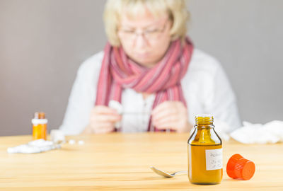 Woman taking medicine while sitting at table