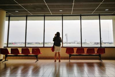 Rear view of woman standing at airport