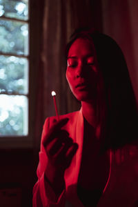 Portrait of young woman smoking cigarette