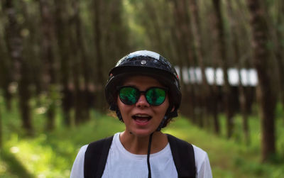 Portrait of young man standing in forest