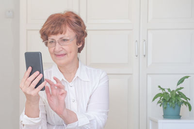 Senior woman using mobile phone at home. shopping online. people connection, virtual communication,