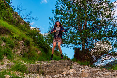 Portrait of young woman against trees