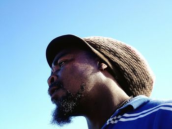 Close-up of bearded man against clear blue sky