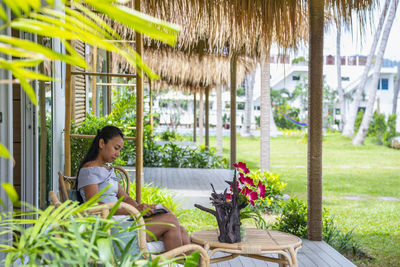 Woman reading in front of holiday home in phuket