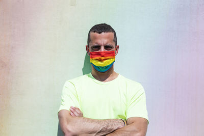 Young man with protective mask and rainbow flag armband. lgtb.