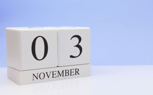 Close-up of november date on table against blue background