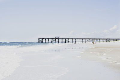 Pier on beach against sky