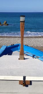 Deck chairs on beach against sea