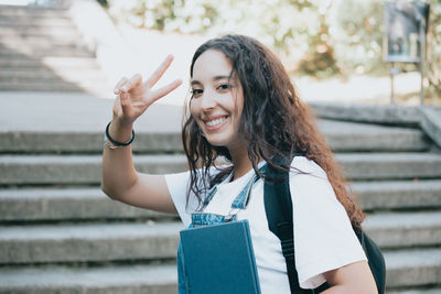 Portrait of young woman standing against wall