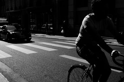 Man riding bicycle on city street at night