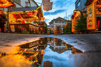 Reflection of illuminated buildings in city at dusk