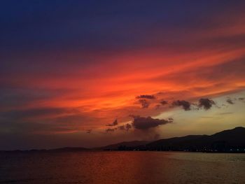 Scenic view of sea against dramatic sky during sunset