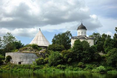 Building by lake against sky