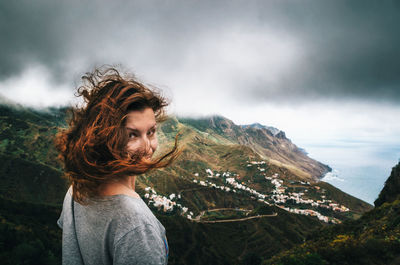 Woman standing on mountain against sky