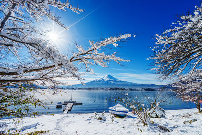 Scenic view of lake against blue sky during winter