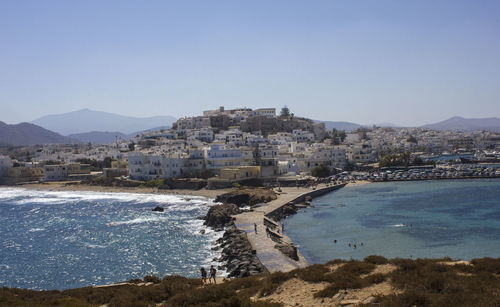 Scenic view of sea and buildings against clear sky