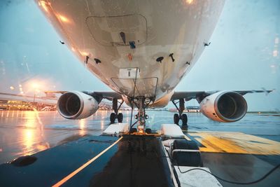 View of airplane at airport runway against sky